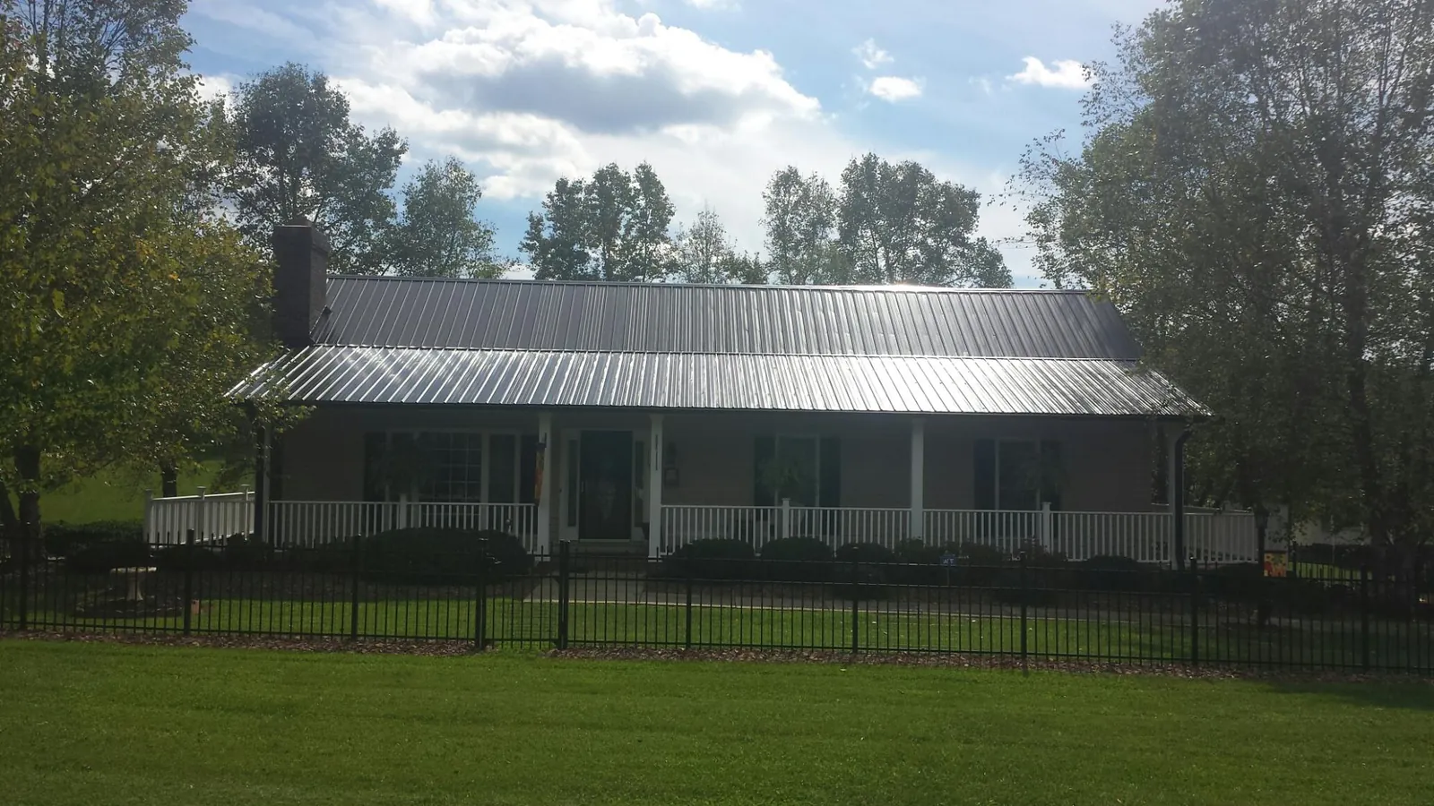 Gray metal roof on a brick ranch with a full width front porch — Gutter Guard Installation work by our crew in Central Point