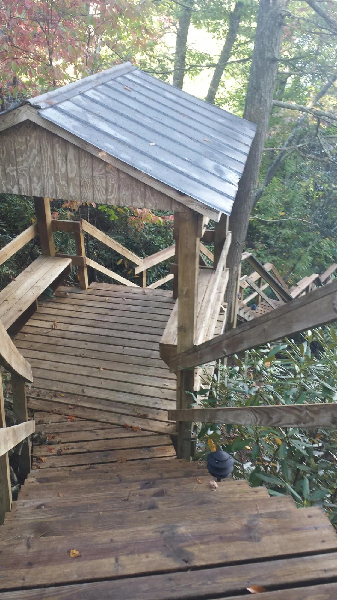 Metal roofed shelter over wooden steps on a wooded walkway — Skylight Repair & Installation work by our crew in Central Point